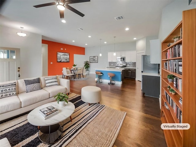 living room featuring a ceiling fan, visible vents, dark wood-style flooring, and recessed lighting