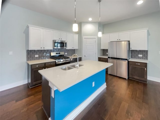 kitchen with white cabinets, stainless steel appliances, a sink, and light countertops