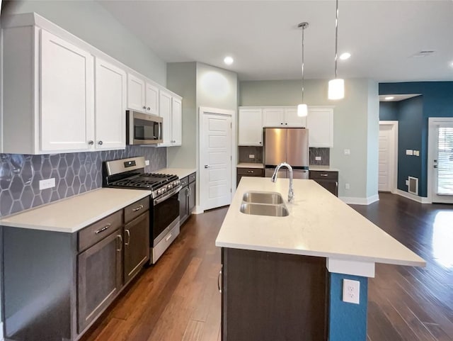 kitchen featuring stainless steel appliances, dark wood finished floors, a sink, and light countertops