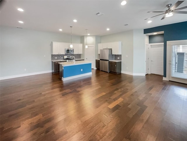 kitchen with stainless steel appliances, light countertops, dark wood finished floors, and tasteful backsplash