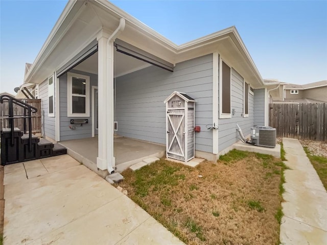 exterior space with fence, cooling unit, and a patio