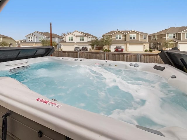 exterior space with a hot tub, a residential view, and fence