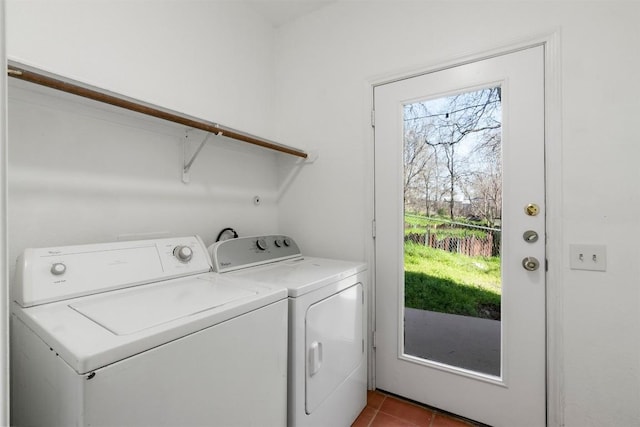 clothes washing area featuring laundry area, tile patterned flooring, and washing machine and dryer