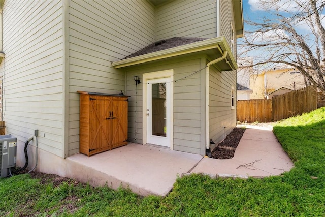 view of exterior entry with central AC unit and fence