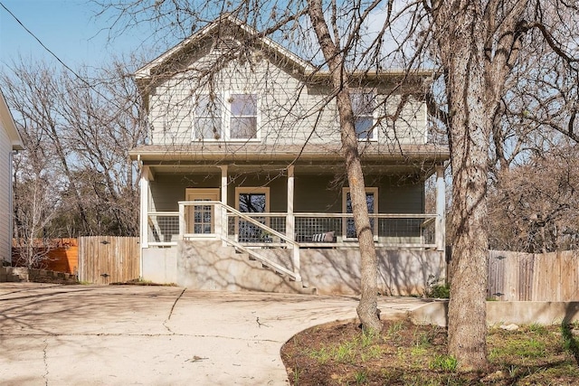 view of front facade featuring covered porch and fence