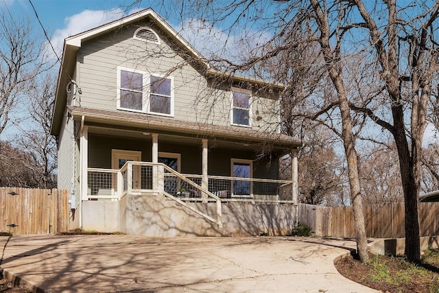 view of front facade with a porch, fence, and stairs