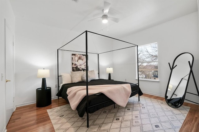 bedroom with ceiling fan, baseboards, and wood finished floors