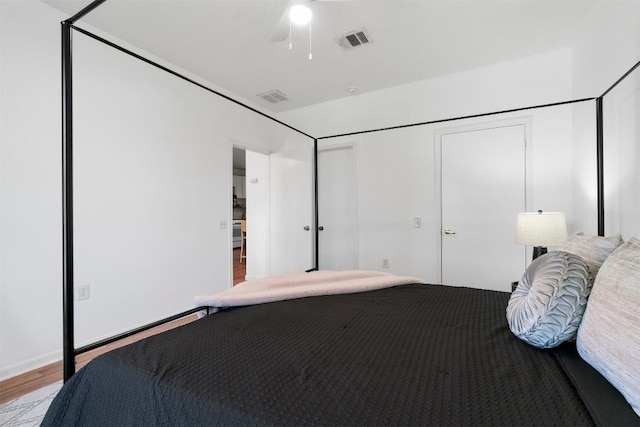 unfurnished bedroom with a ceiling fan, visible vents, and wood finished floors