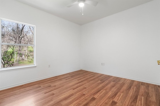 unfurnished room featuring baseboards, a ceiling fan, and light wood-style floors