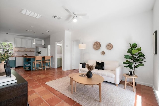 living room with light tile patterned floors, visible vents, and baseboards