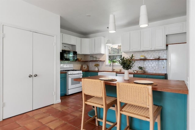 kitchen featuring black microwave, white cabinets, white gas range oven, open shelves, and decorative light fixtures