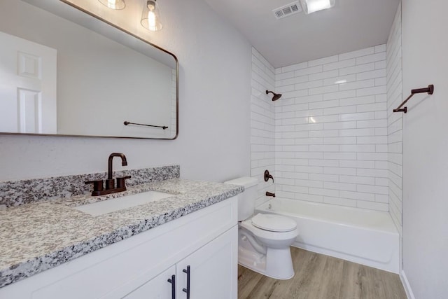 full bathroom featuring visible vents, toilet, wood finished floors,  shower combination, and vanity