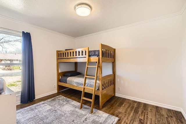 bedroom with multiple windows, baseboards, and wood finished floors