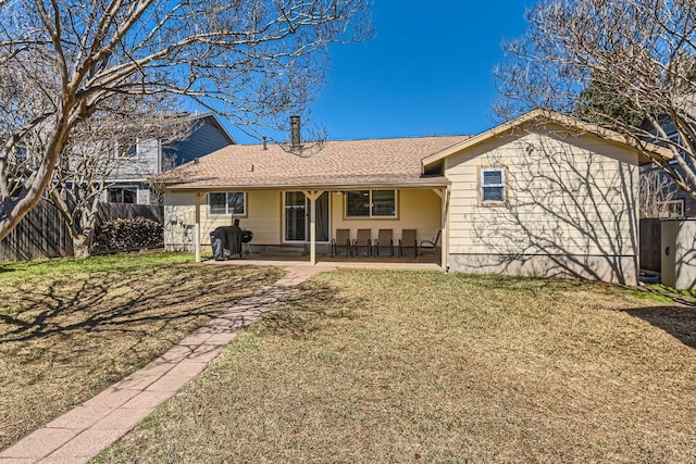 back of property featuring a yard, fence, and a patio