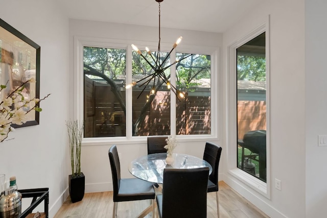 dining room featuring baseboards, an inviting chandelier, and wood finished floors