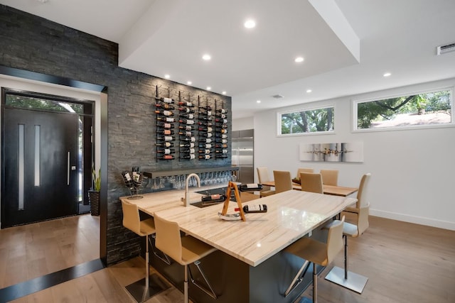 wine cellar with baseboards, wood finished floors, visible vents, and recessed lighting