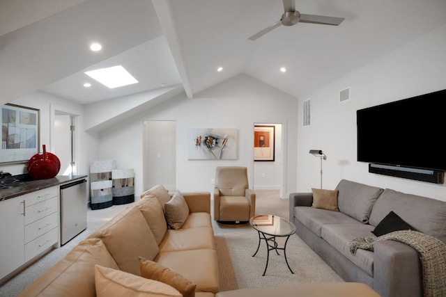 living room with light carpet, lofted ceiling with skylight, visible vents, and a ceiling fan