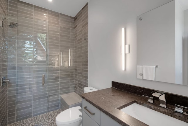 bathroom with toilet, a shower stall, and vanity