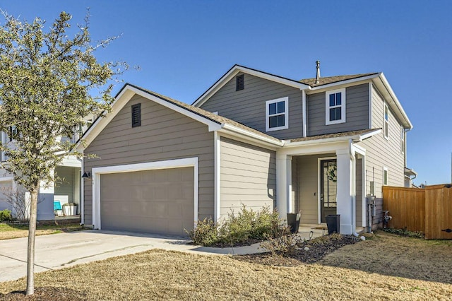 traditional-style home with a shingled roof, concrete driveway, a garage, and fence