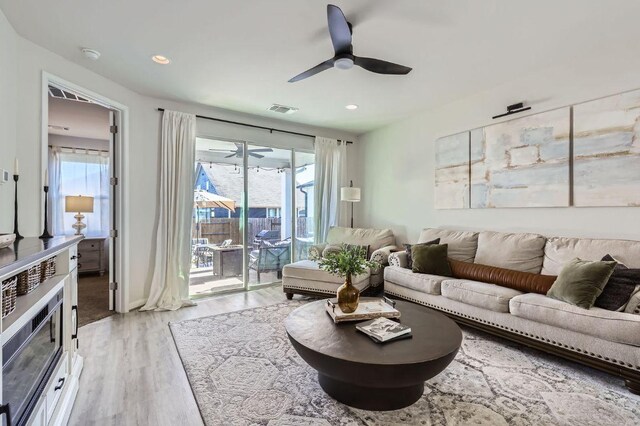 349 High Plains Pass, Liberty Hill, TX 78642 - living room featuring light wood finished floors, a ceiling fan, plenty of natural light, and recessed lighting