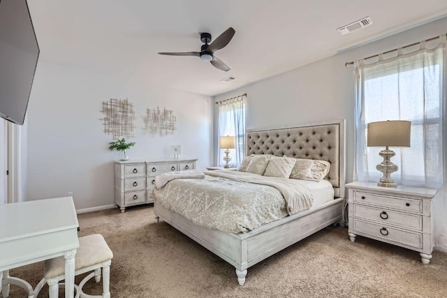 bedroom featuring light carpet, visible vents, baseboards, and ceiling fan