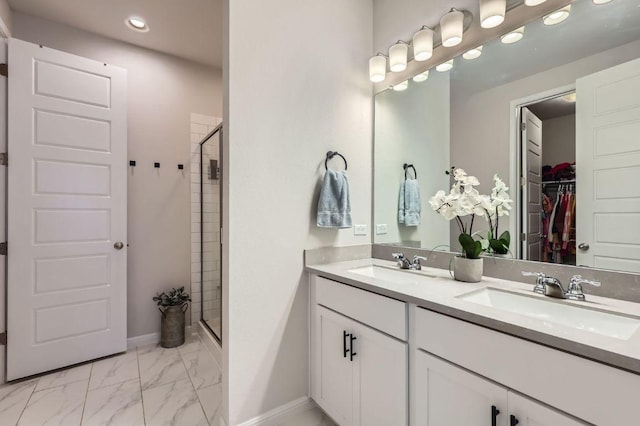 bathroom featuring double vanity, marble finish floor, a shower stall, and a sink