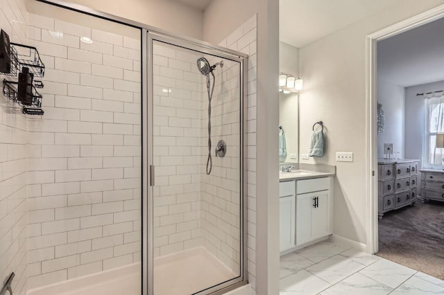 full bath with marble finish floor, vanity, a shower stall, and baseboards