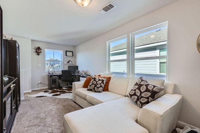 carpeted living area featuring visible vents and baseboards