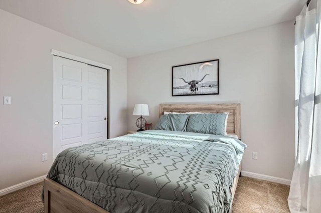 bedroom with a closet, baseboards, and carpet