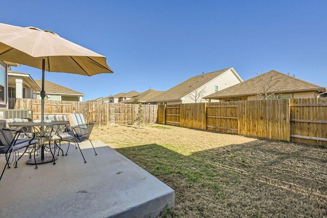 view of yard featuring a patio, outdoor dining area, and a fenced backyard