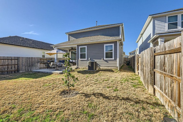 back of house with a ceiling fan, a patio, a yard, and a fenced backyard