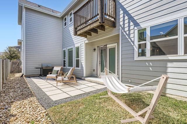 rear view of house with fence, a balcony, and a patio