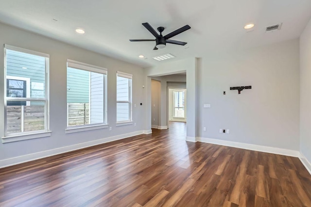 empty room with recessed lighting, visible vents, dark wood-type flooring, a ceiling fan, and baseboards