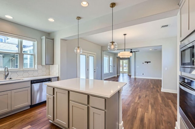 kitchen featuring visible vents, appliances with stainless steel finishes, gray cabinets, and a sink