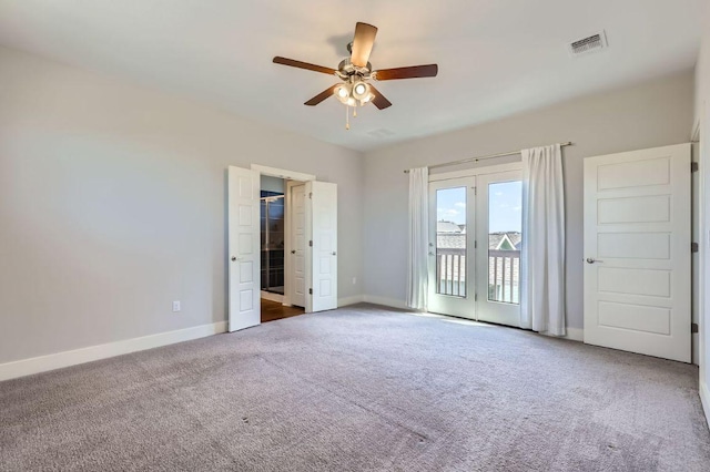 empty room with carpet, visible vents, ceiling fan, and baseboards