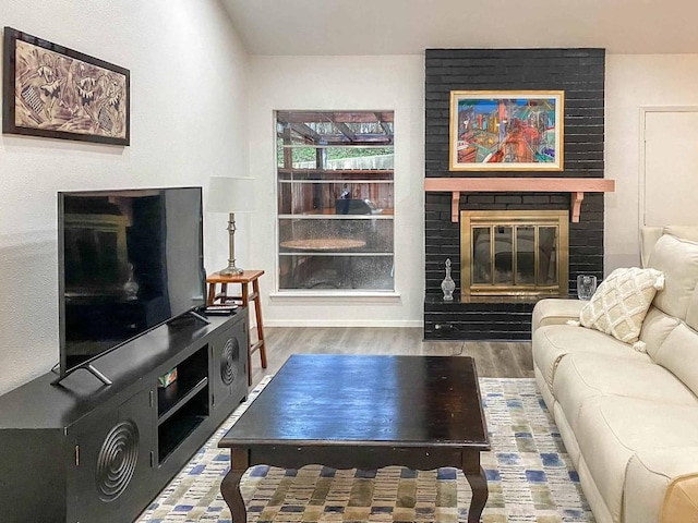 living room with a fireplace and wood finished floors