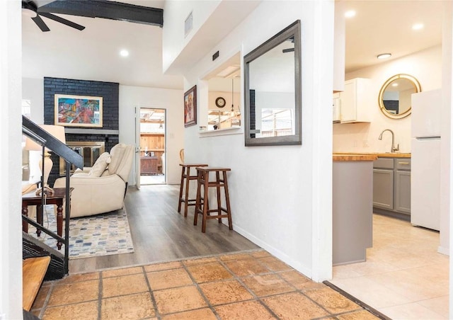 7215 Coronado Cir, Austin, TX 78752 - living room with a ceiling fan, baseboards, a brick fireplace, and recessed lighting