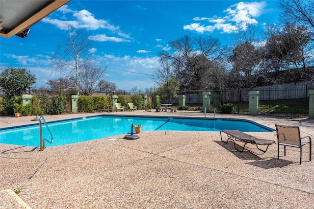 pool with a patio area and fence