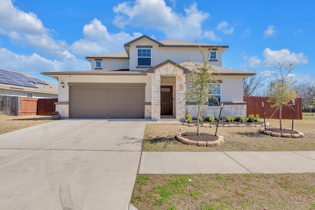 view of front of house with stone siding, fence, concrete driveway, and stucco siding