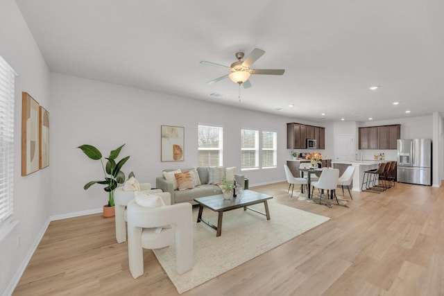 living room with recessed lighting, visible vents, baseboards, a ceiling fan, and light wood-style floors