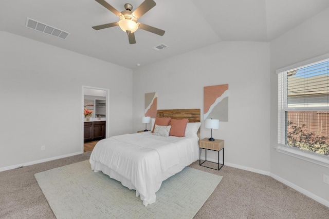 carpeted bedroom featuring connected bathroom, visible vents, vaulted ceiling, and baseboards