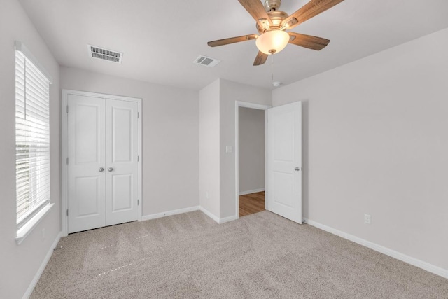 unfurnished bedroom with carpet flooring, visible vents, and baseboards