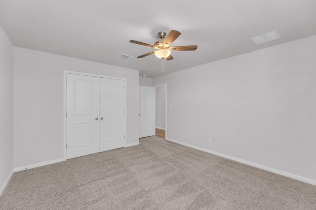 unfurnished bedroom with a closet, carpet, visible vents, and baseboards