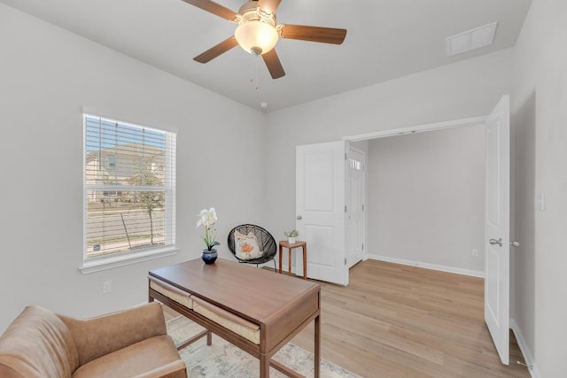 office featuring light wood-type flooring, visible vents, ceiling fan, and baseboards