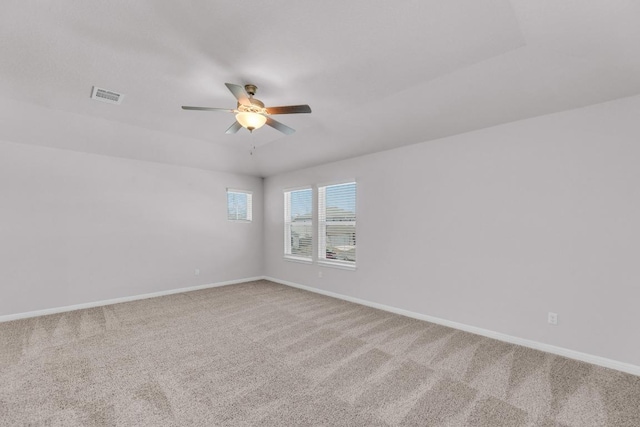 carpeted empty room with ceiling fan, visible vents, and baseboards