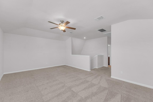 spare room with carpet floors, baseboards, visible vents, and lofted ceiling