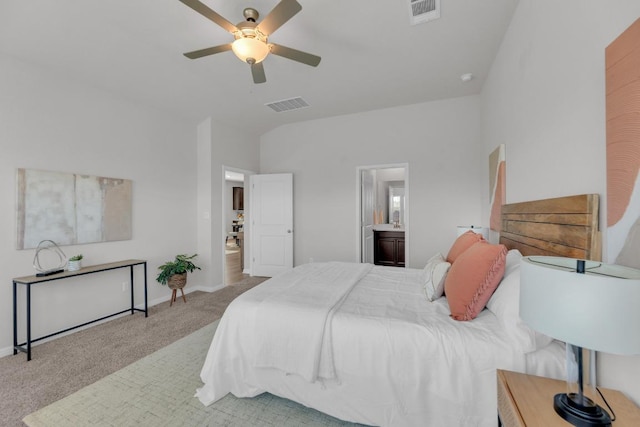 bedroom with carpet, visible vents, lofted ceiling, and ensuite bath