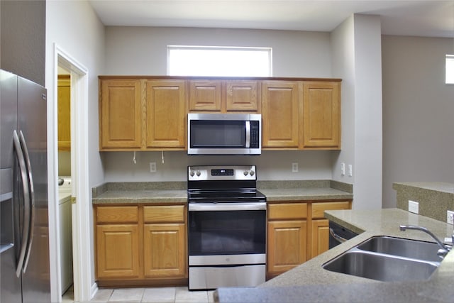 kitchen with light tile patterned floors, stainless steel appliances, and a sink