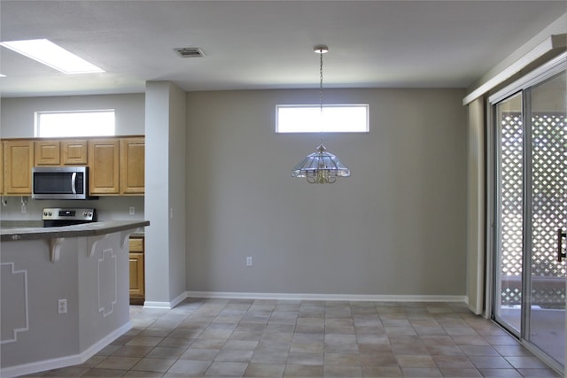 kitchen with appliances with stainless steel finishes, visible vents, plenty of natural light, and a kitchen bar