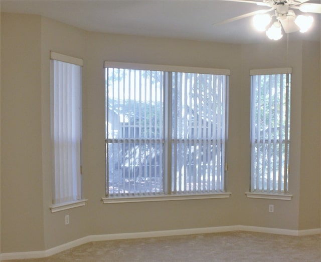 empty room featuring ceiling fan and baseboards